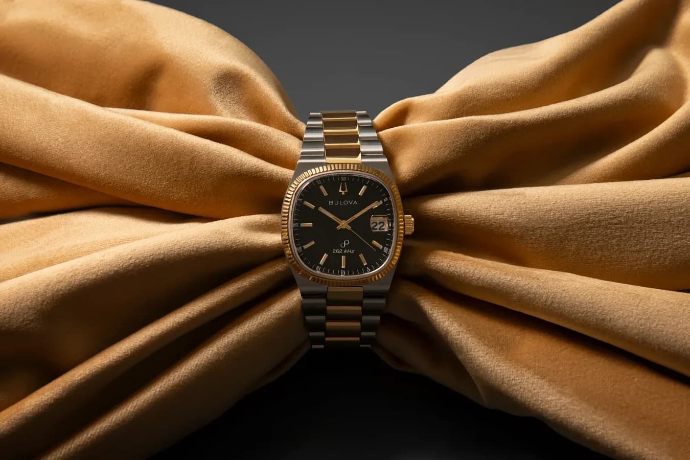 Two-tone Bulova Super Seville with a black dial, wrapped in gold satin