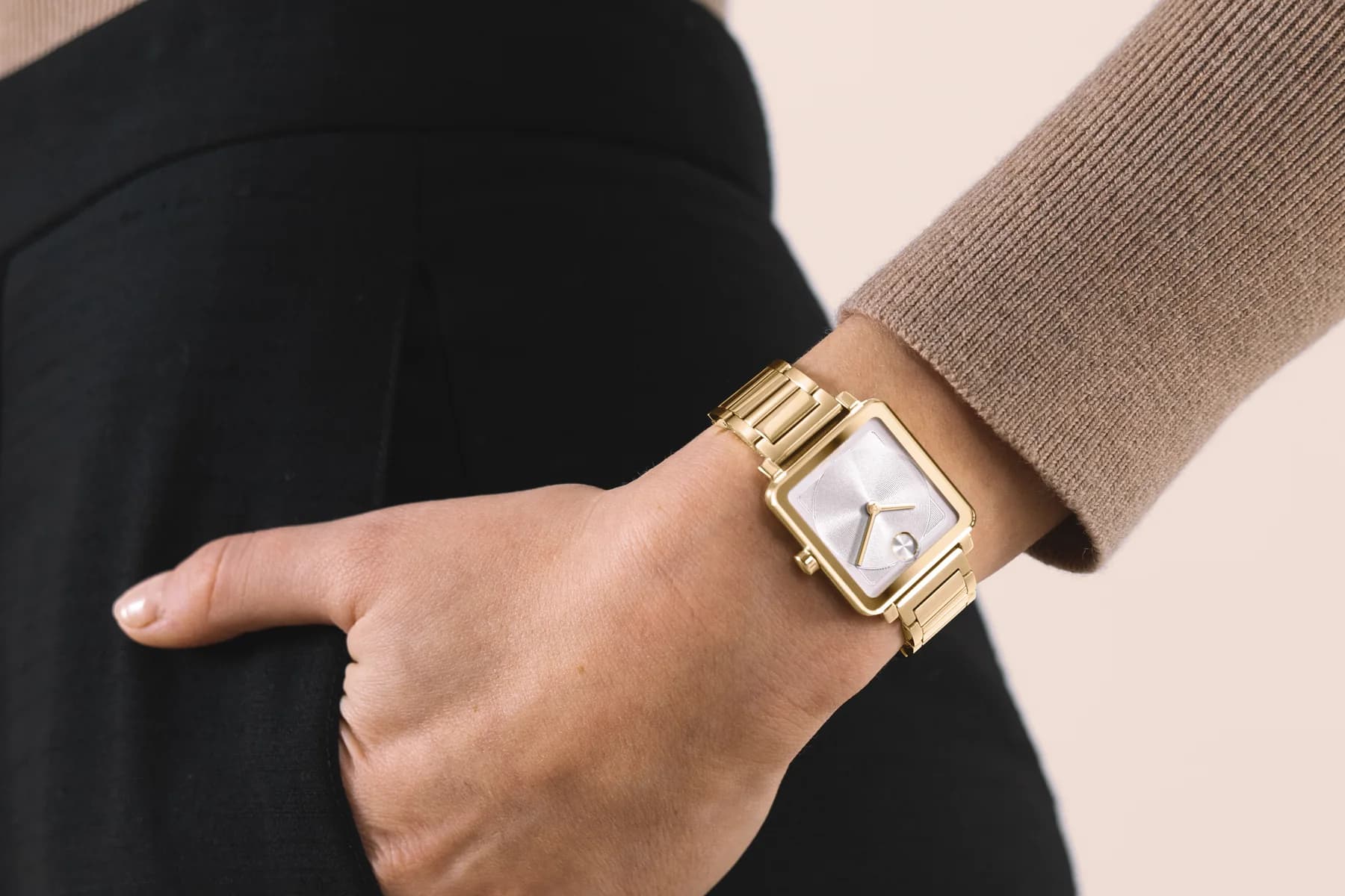 Gold-tone Movado BOLD Evolution 2.0 with a white dial worn on a wrist