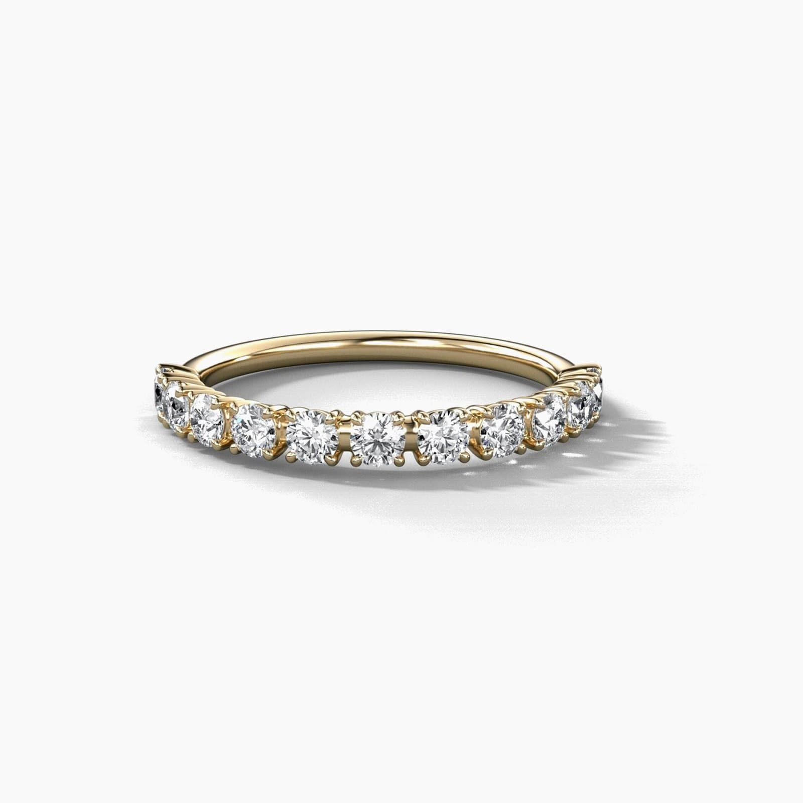 Eleven stone claw prong diamond band in yellow gold