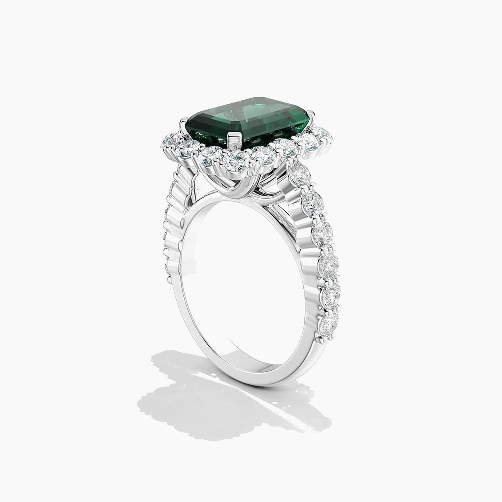 Emerald cut emerald and diamond halo engagement ring in 18K white gold
