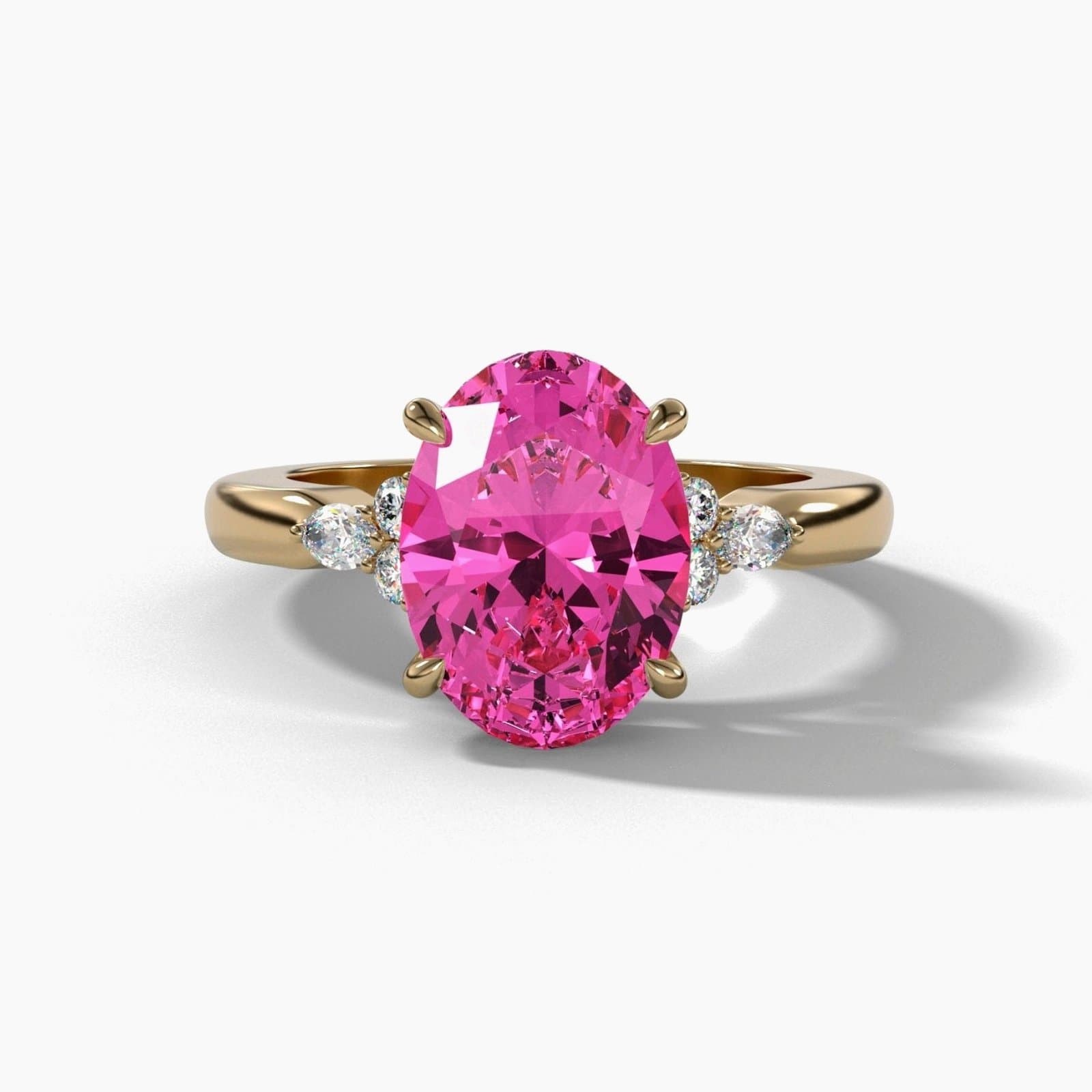 Oval pink sapphire engagement ring in yellow gold