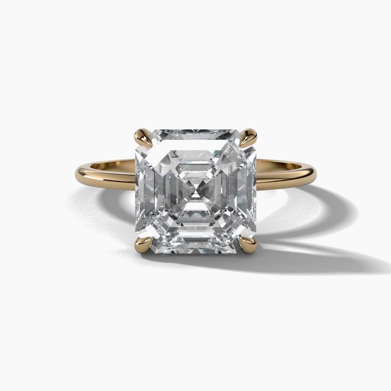 Thin solitaire engagement ring with an Asscher cut diamond in yellow gold