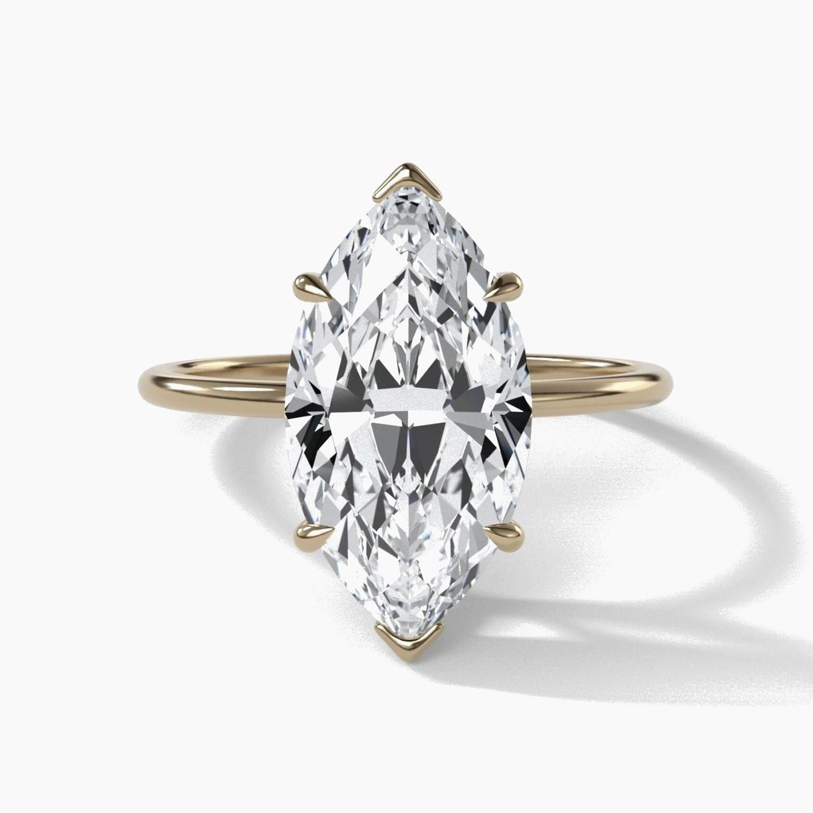 Thin solitaire engagement ring with a marquise diamond in yellow gold