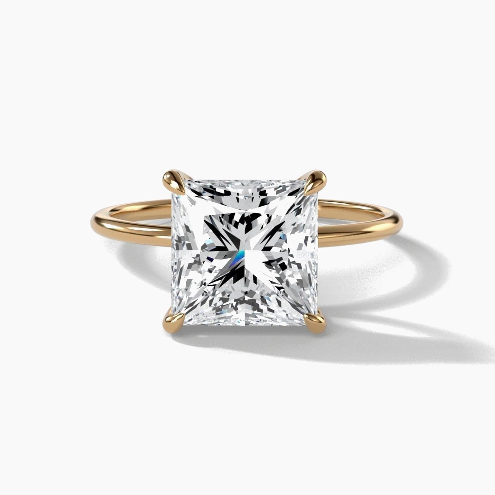 Thin solitaire engagement ring with a princess cut diamond in yellow gold